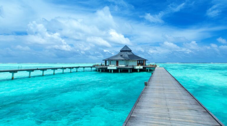 Stunning view of the Maldives featuring turquoise lagoons, white sandy beaches, and luxurious overwater villas surrounded by crystal-clear waters.