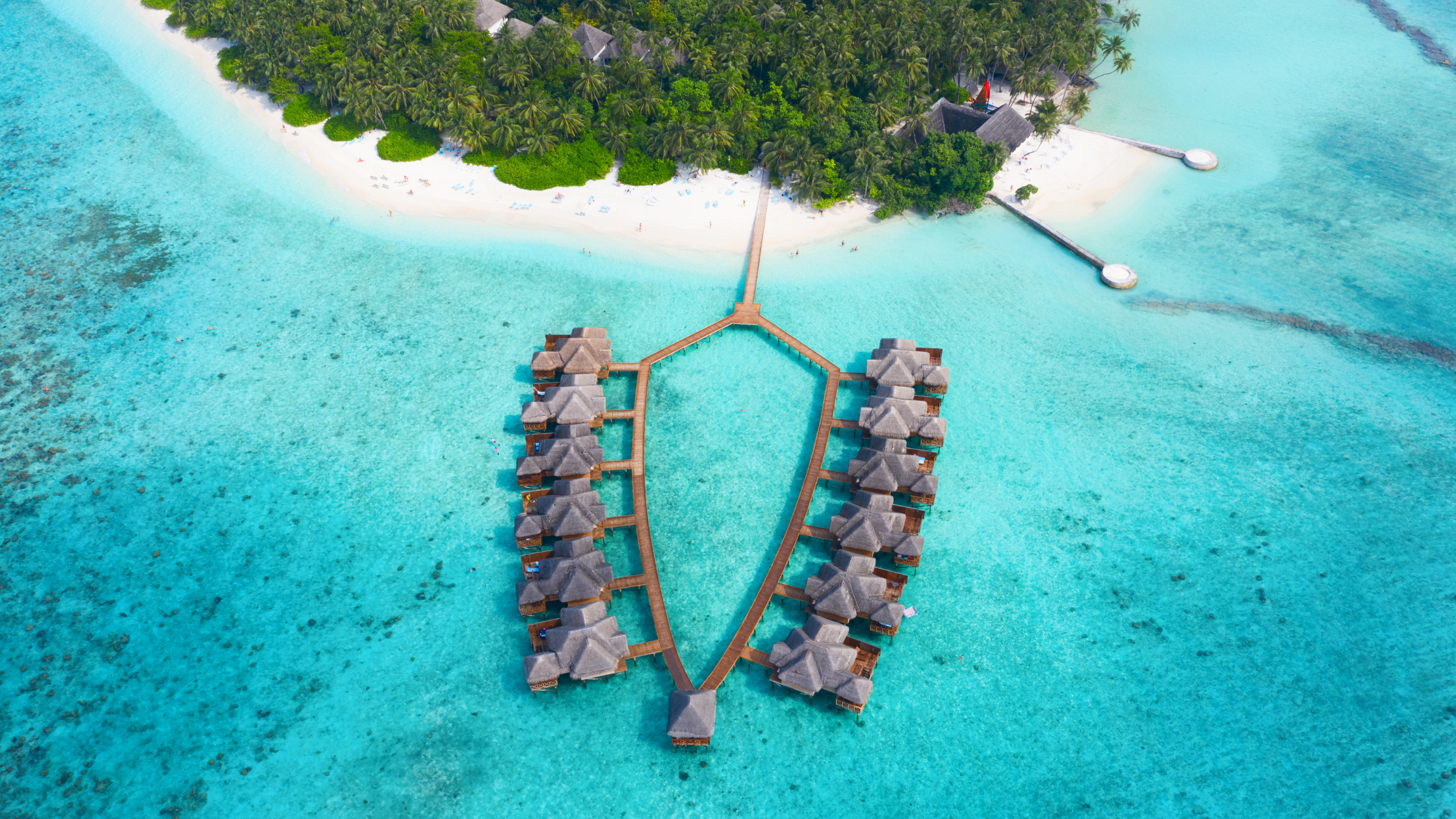 Scenic view of the Maldives with turquoise ocean waters, white sandy beaches, and overwater villas—perfect for travelers dreaming of traveling to the Maldives.