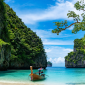 Scenic beach in Thailand with turquoise waters and towering limestone cliffs, showcasing the natural beauty of exploring Thailand’s coastal landscapes.