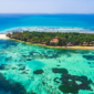 "A breathtaking view of a white sandy beach in Zanzibar, Tanzania, with turquoise waters and traditional dhow boats, perfect for relaxation and adventure while visiting Zanzibar."