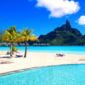 Bora Bora travel guide – A breathtaking view of Bora Bora’s pristine beach with crystal-clear turquoise waters, white sand, and lush tropical scenery