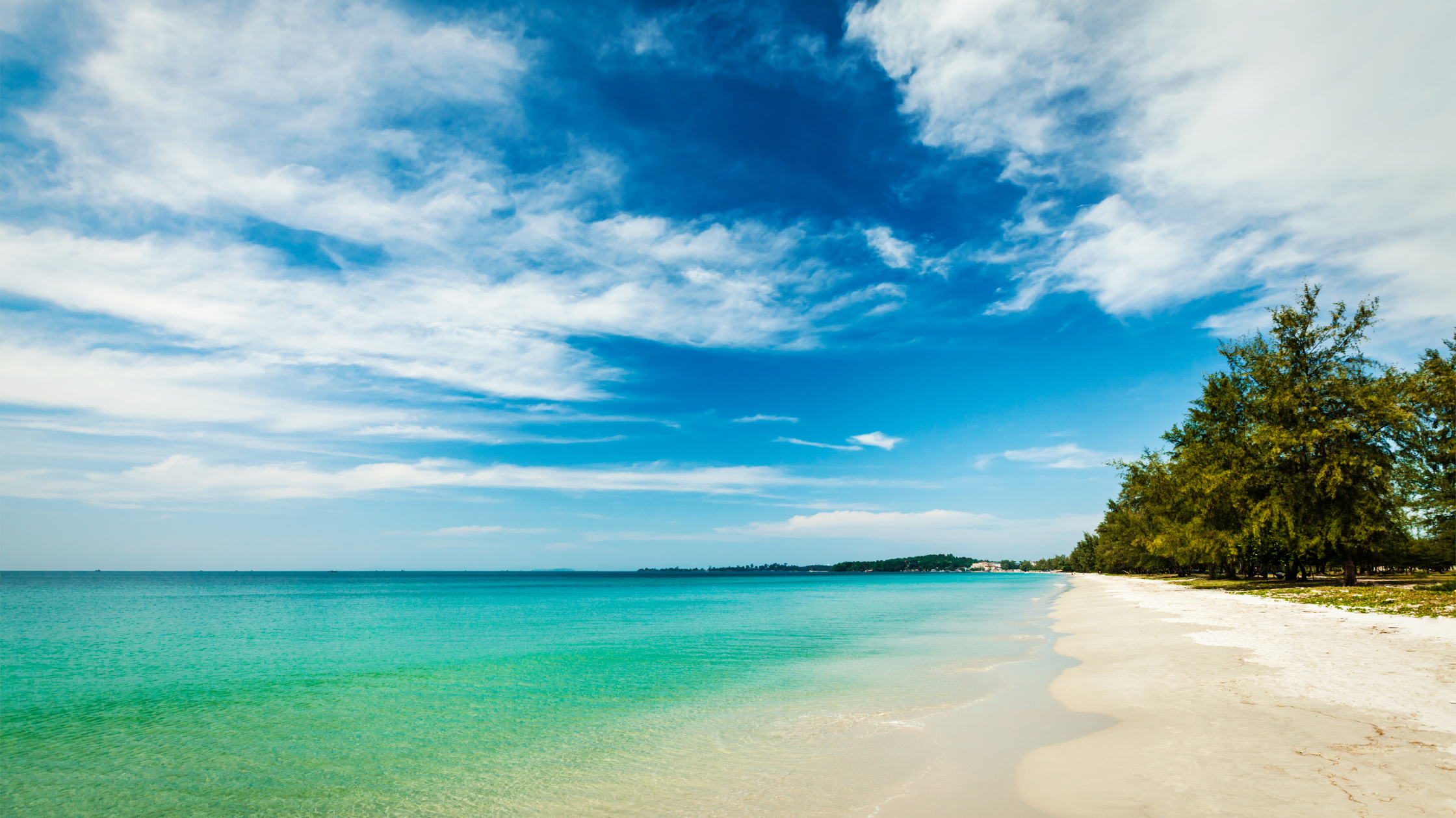 "A stunning tropical beach on Koh Rong with crystal-clear waters, white sand, and lush palm trees – the perfect island getaway