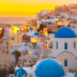 A breathtaking sunset over Santorini, Greece, with golden hues reflecting on the white-washed buildings and the deep blue Aegean Sea."