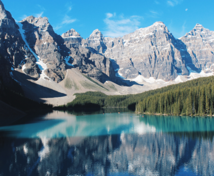 "Stunning lake view in Banff National Park, surrounded by towering mountains and lush forests – a must-visit travel destination in the Canadian Rockies