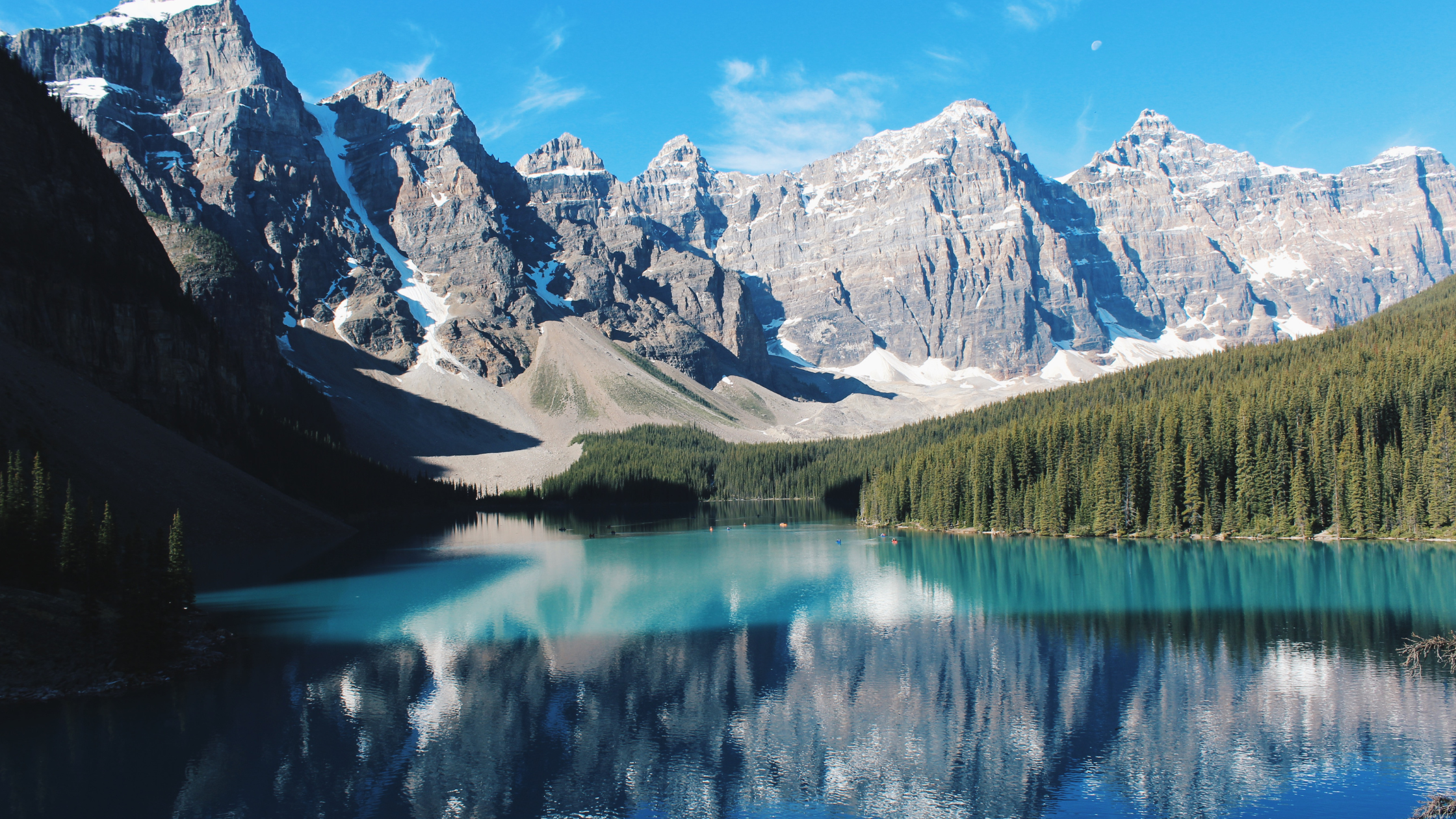 "Stunning lake view in Banff National Park, surrounded by towering mountains and lush forests – a must-visit travel destination in the Canadian Rockies